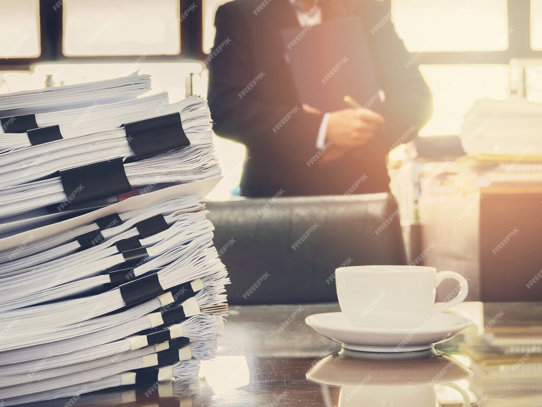 Close up of stack of documents and a cup of coffee