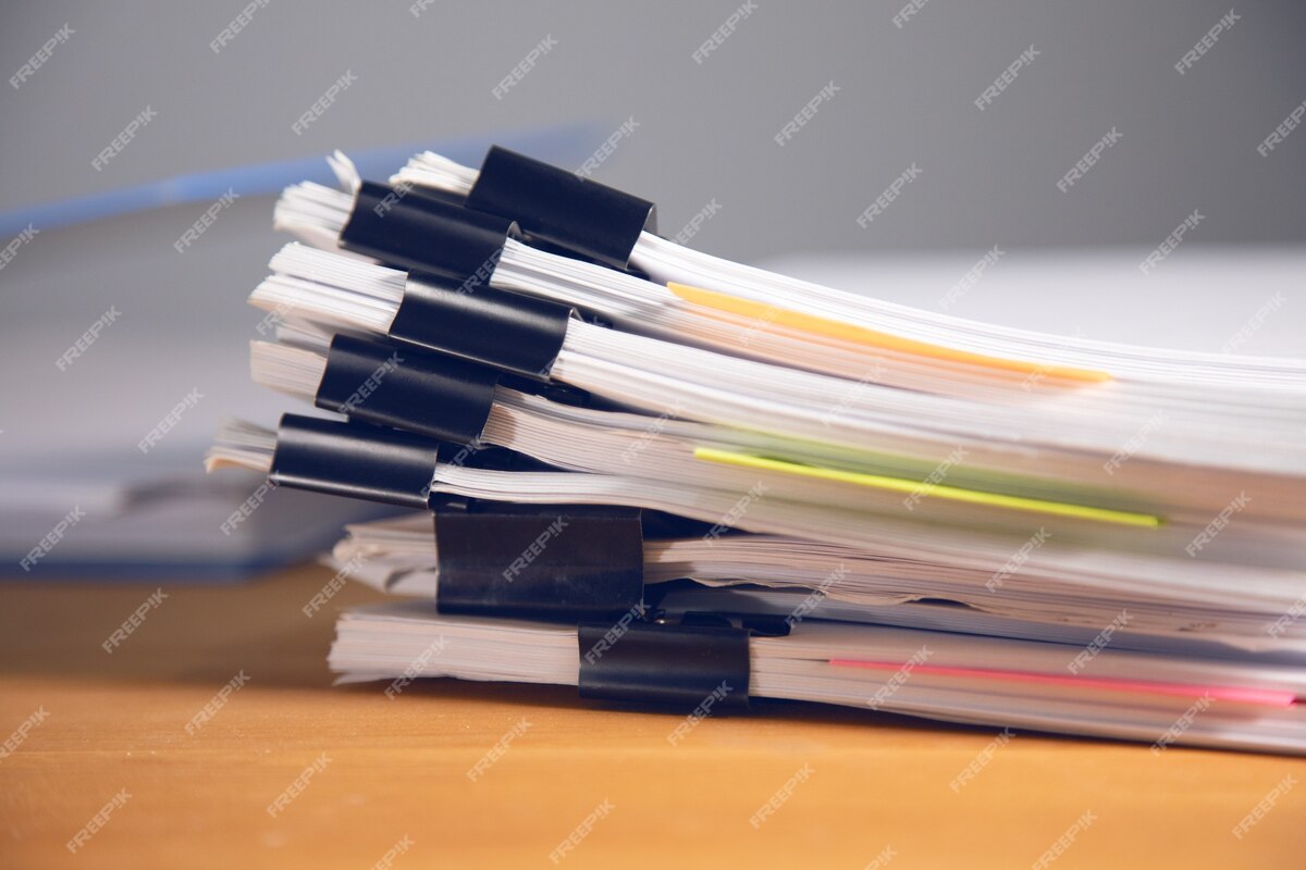 Stacks of many binders with files, folders on office desk