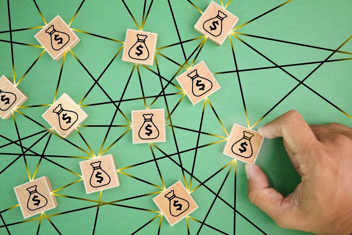 A person is drawing a bag of money with the words on it.